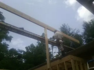Carpenter setting a ridge beam over a new addition frame — Ice Dam Removal by Roofing Brothers in Walhonding
