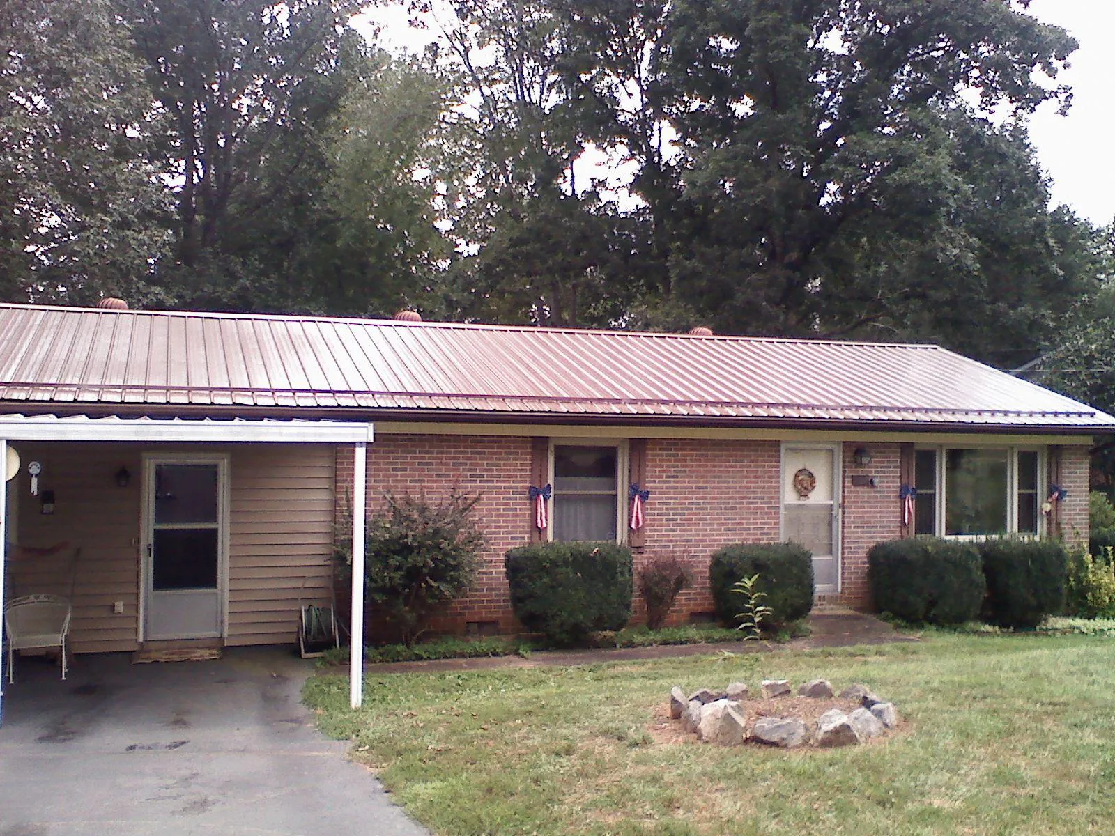 Bronze metal roof and carport on a brick ranch home — Roof Repair work by our crew in Walhonding